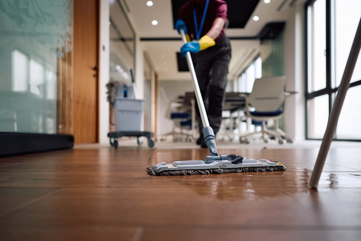 Professional cleaning team mopping and cleaning a space